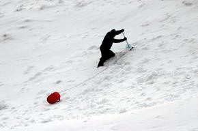 Skifahrer im Steilhang, der rote Ball hängt an der Leine hinter ihm