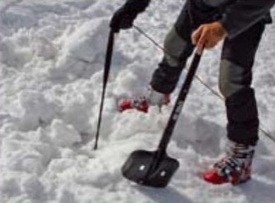 Rescuer digging with a shovel right at the line