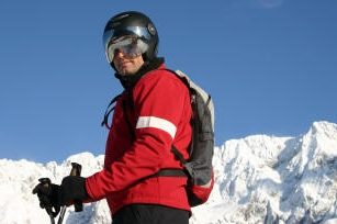 Skifahrer mit Powderbag vor Bergpanorama