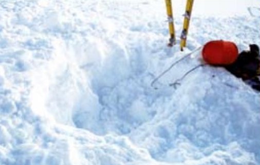 Person dug out, next to the red ball and ski poles